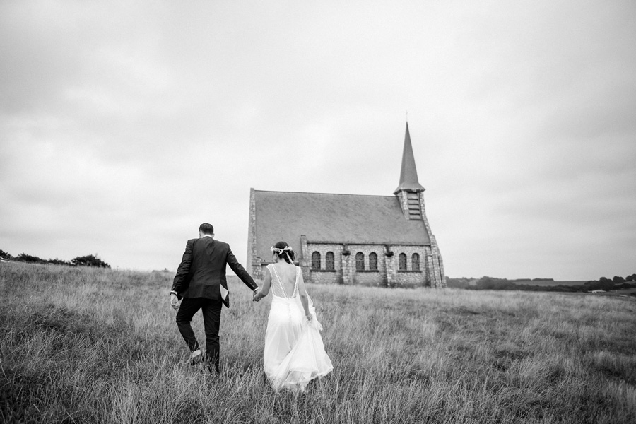 un couple se dirige vers une église en pleine campagne