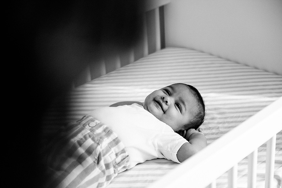 un bébé est allongé dans son lit et sourit