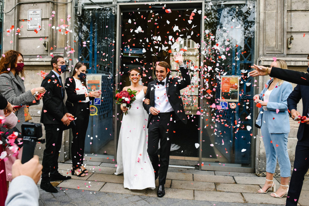 Les jeunes mariés sortent de la mairie sous les confettis