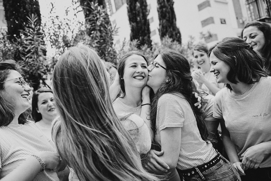 une femme souriante est embrassée par ses amies