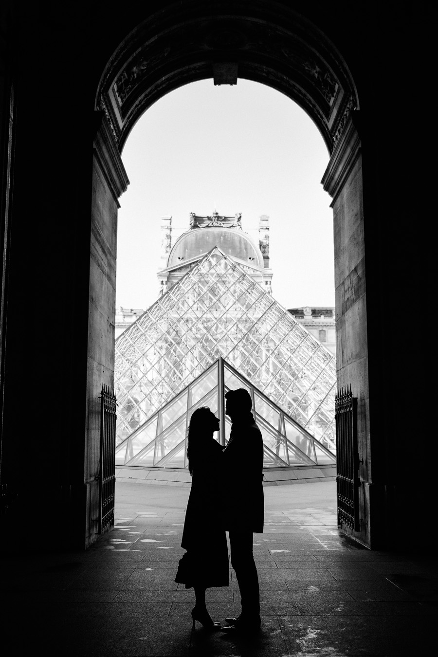 La silhouette d'un couple devant la pyramide du Louvre