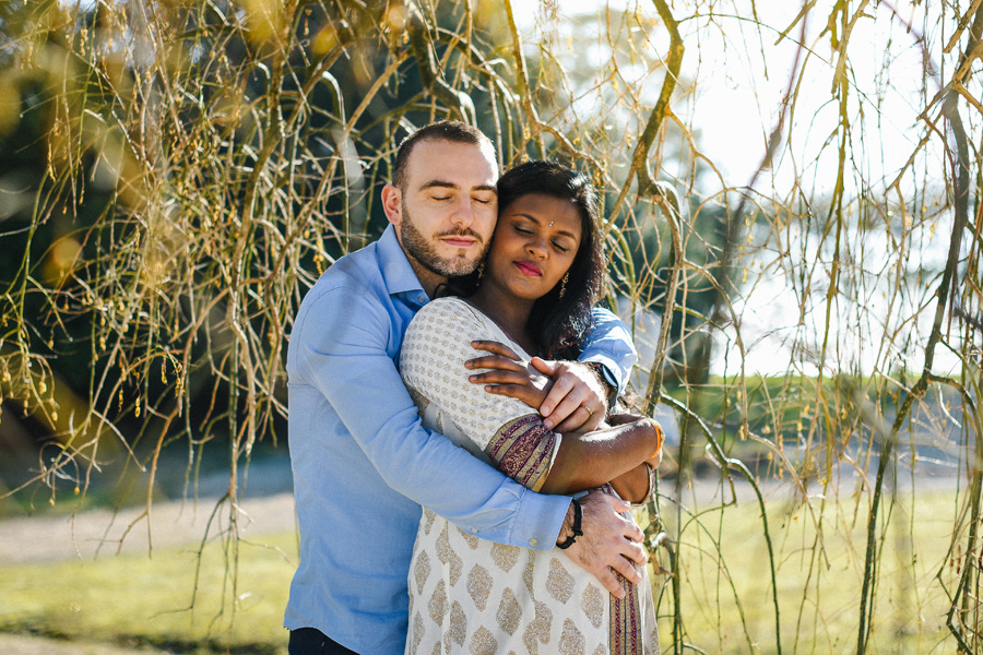 un homme et une femme s'enlacent sous un arbre
