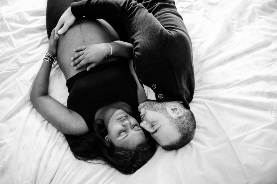 une femme enceinte est allongée sur un lit avec son mari