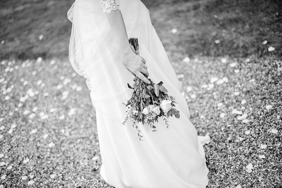 la mariée tient son bouquet de fleurs dans la main