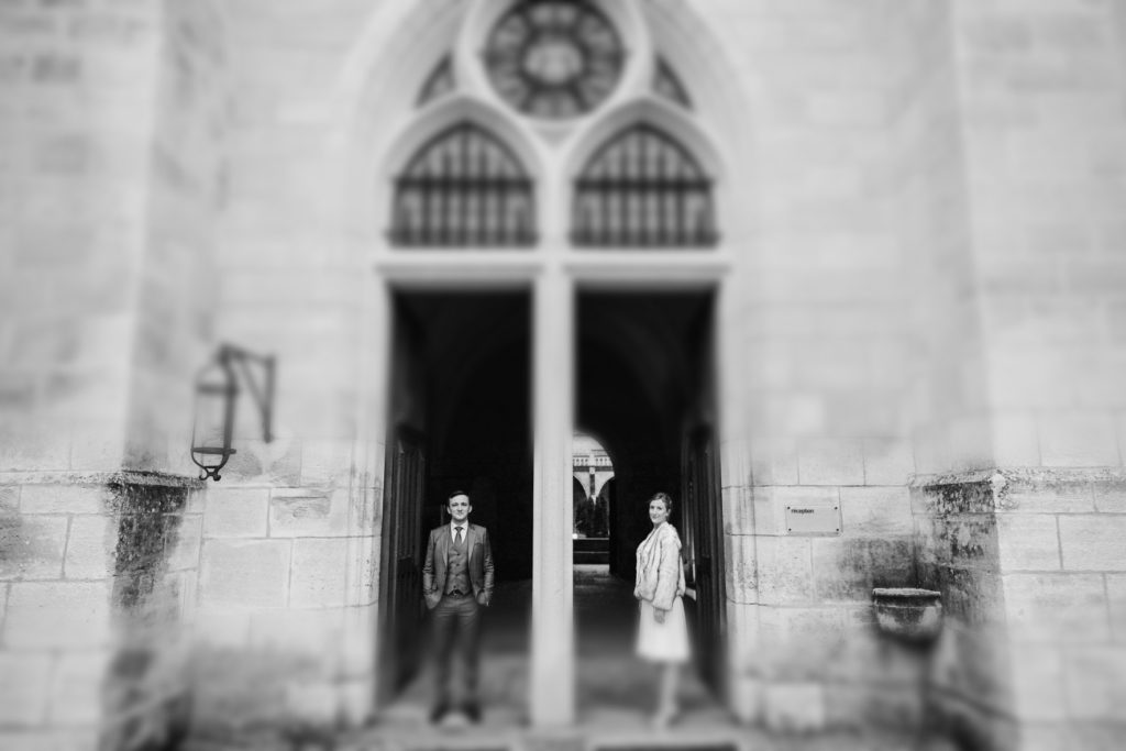 Le couple de mariés se tient devant les murs de l'abbaye