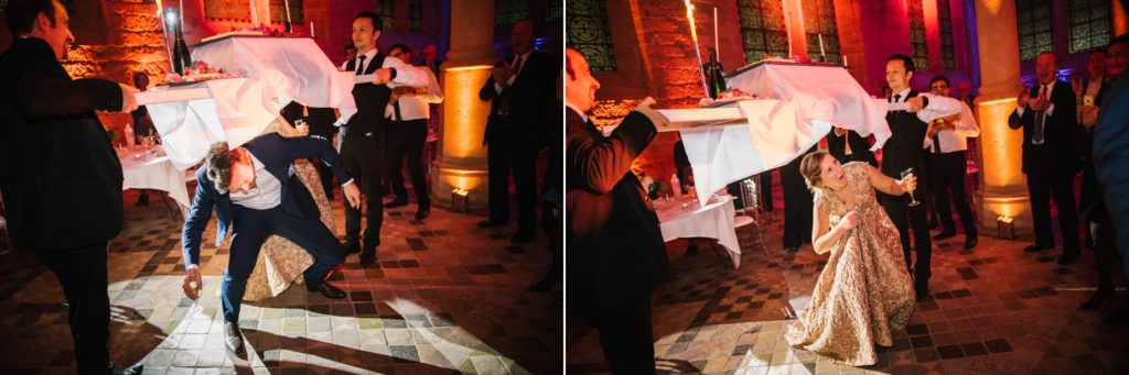 Les mariés se baissent pour passer sous la table du gâteau